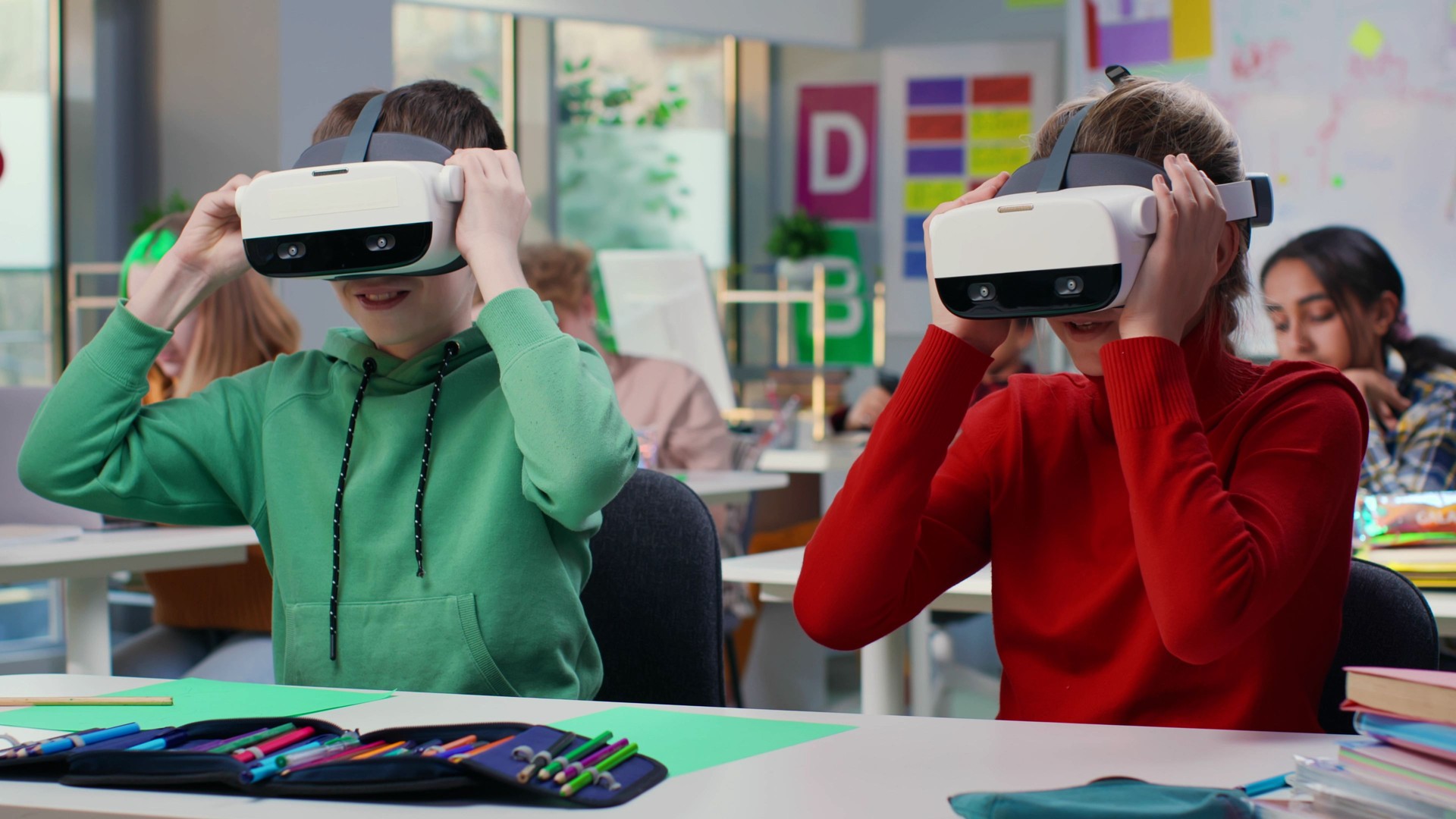 Portrait of schoolkids sitting at desk and putting on vr headset in classroom